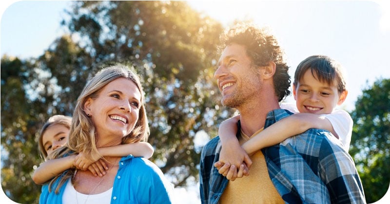 smiling family with two young children and mother and father